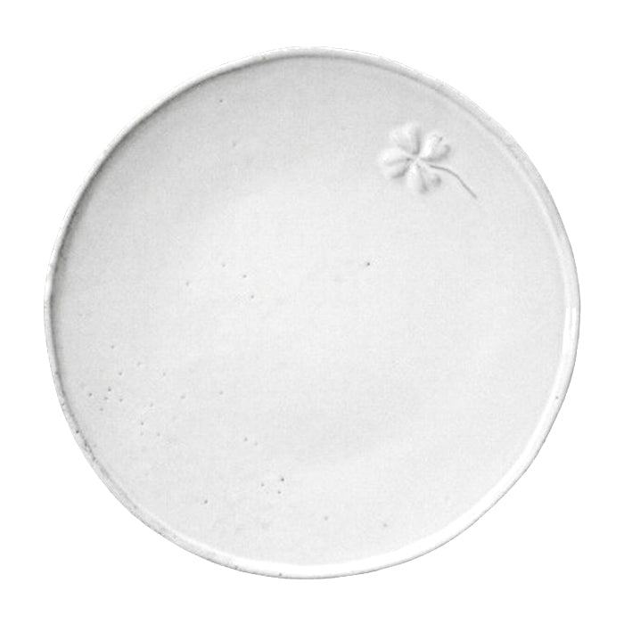 Round ceramic side plate with a raised four leaf clover design and a milky white glaze.