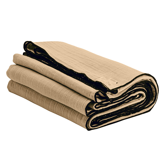 Beige folded cotton gauze tablecloth with black sewn edges.