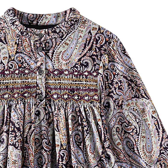 Close up of the smocking across the chest and all over purple paisley print.