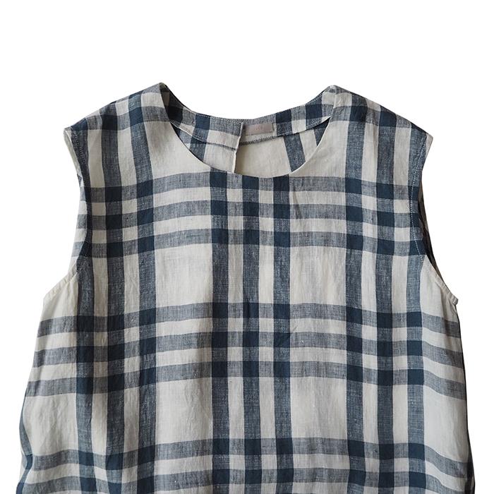 Close up of the sleeveless dress in off-white with a large blue check pattern.