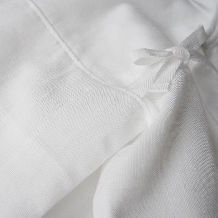 Close up of the woven cotton gauze fabric and tie closure.