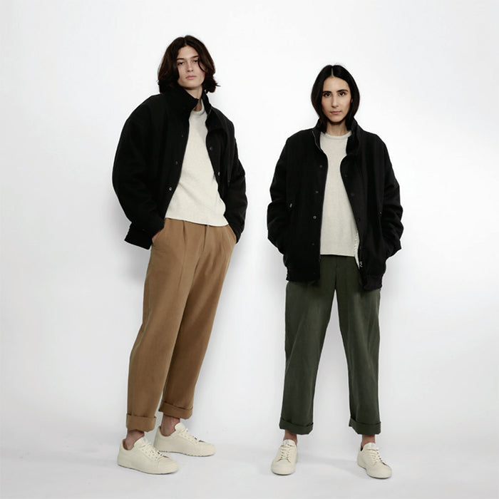 A man and woman wearing black long sleeved shirt jackets.