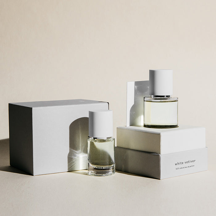 Two perfume bottles artfully arranged with their presentation boxes.