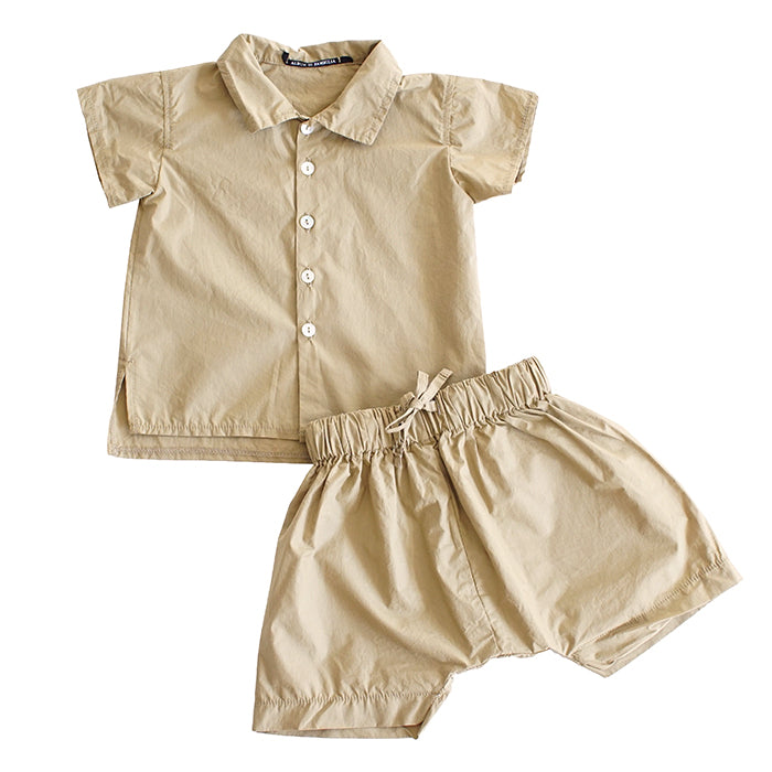 Short sleeved button up shirt with a collar in gold yellow and matching shorts.