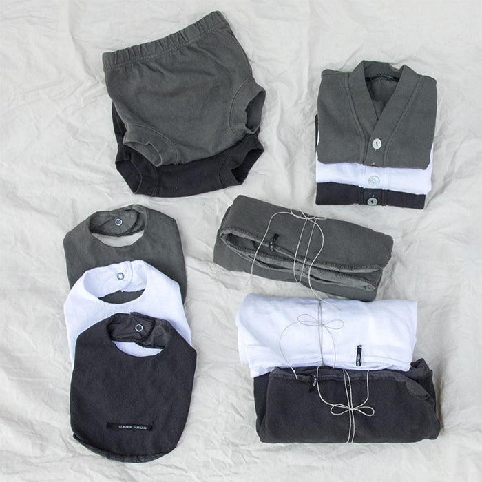 Monochrome baby clothing including three colours of bibs.