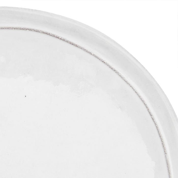 Close up of the milky white glaze and raised rim.