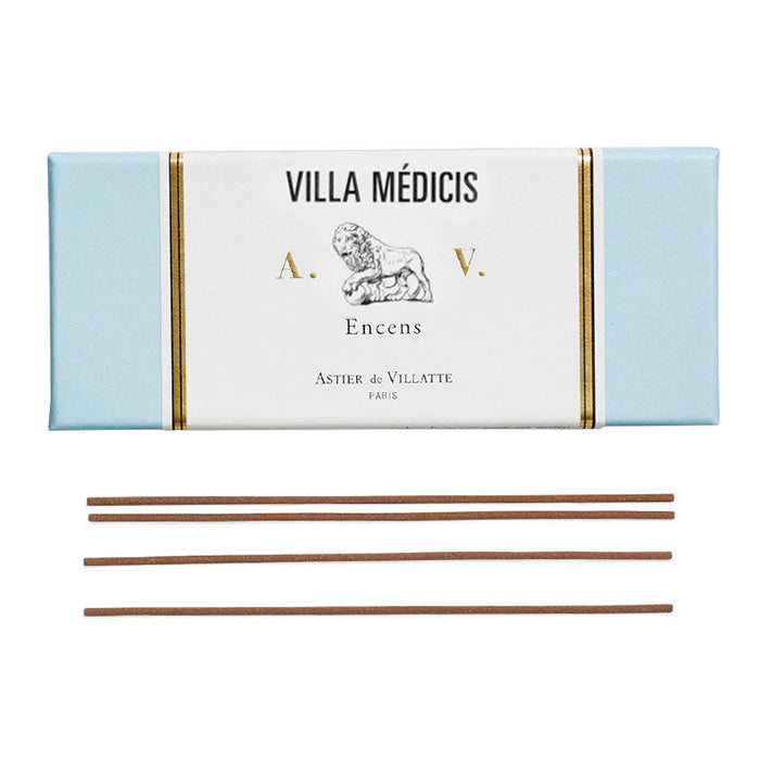 Light blue box of incense with a vintage label with gold details next to some sticks on incense.