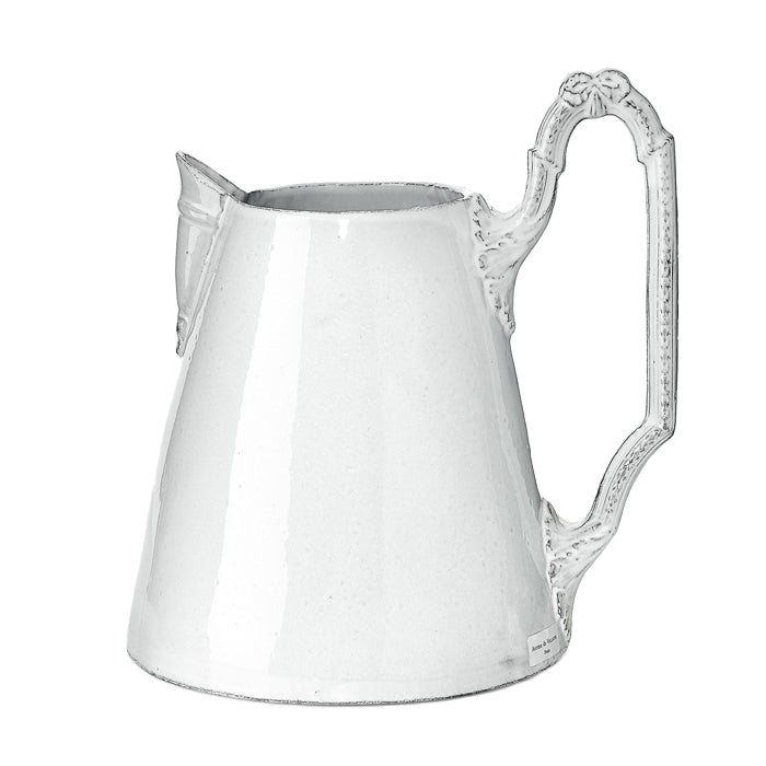 Large ceramic pitcher with a decorative handle in a milky white glaze.