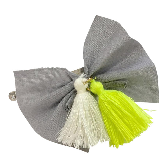 Hair clip with a grey fabric bow and cream and green tassels.