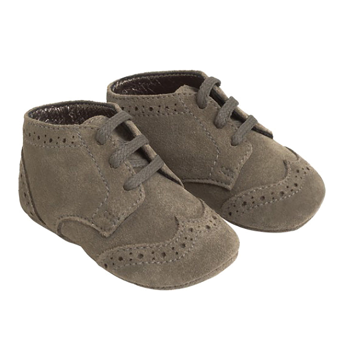 A pair of grey green suede shoes with oxford style details from the side.