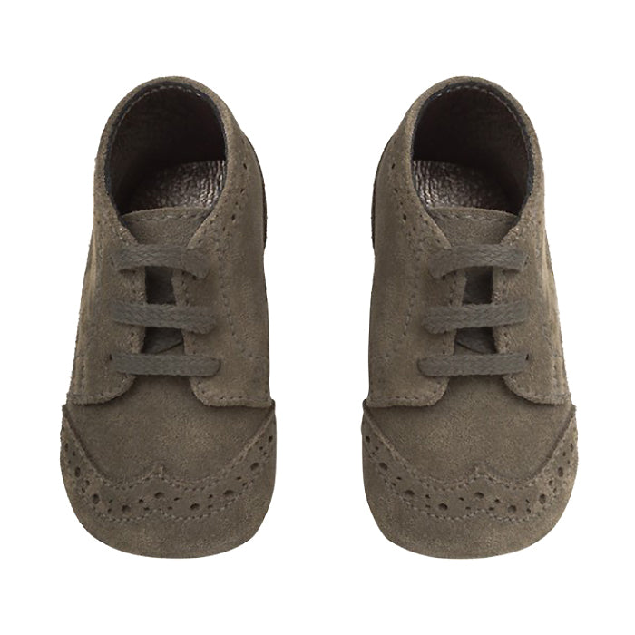 A pair of grey green suede shoes with oxford style details from the front.