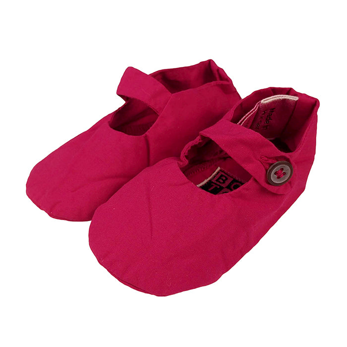 Magenta pink soft cotton baby slippers with a buttoned strap across the foot.