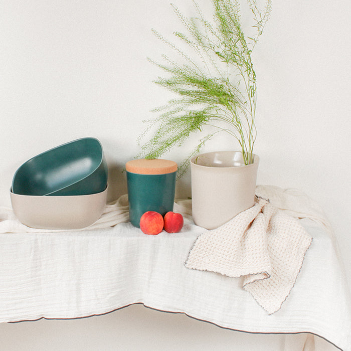 Cream cotton gauze tablecloth with black sewn edges on a table.