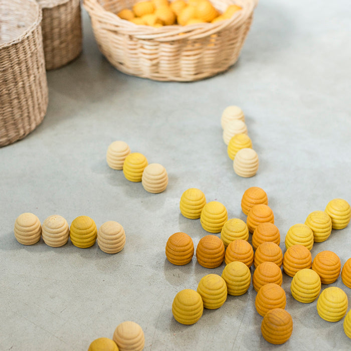Wooden mini honeycomb shaped pieces in various shades of yellow in a star pattern.
