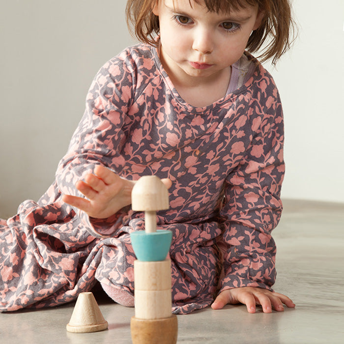 Child playing with wooden stacking toy with six beads on a pole.
