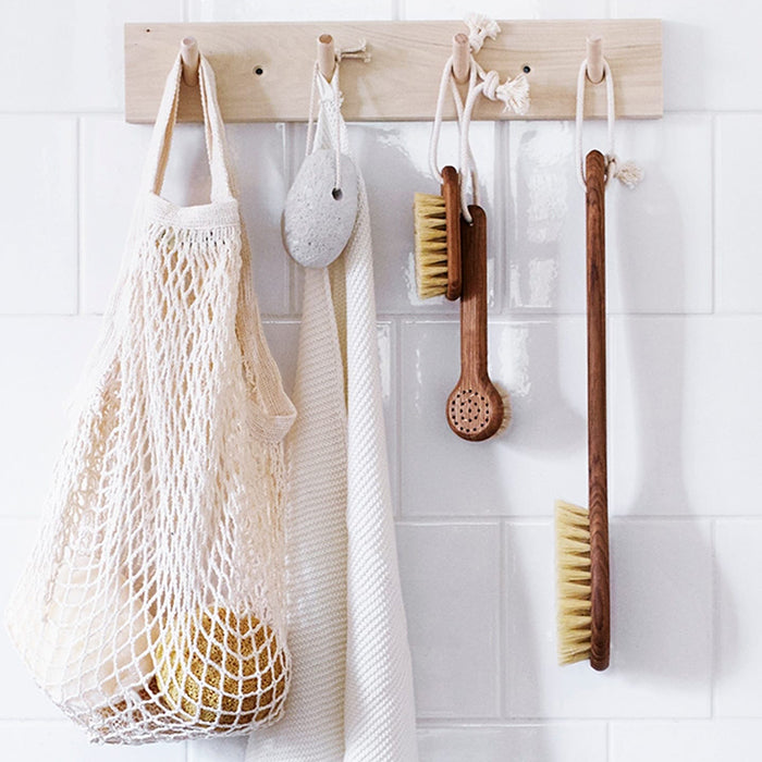 Bath brushes and a towel hanging from a rack in a bathroom.