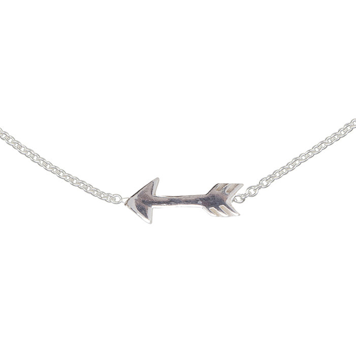 A close up of a silver chain and arrow charm.