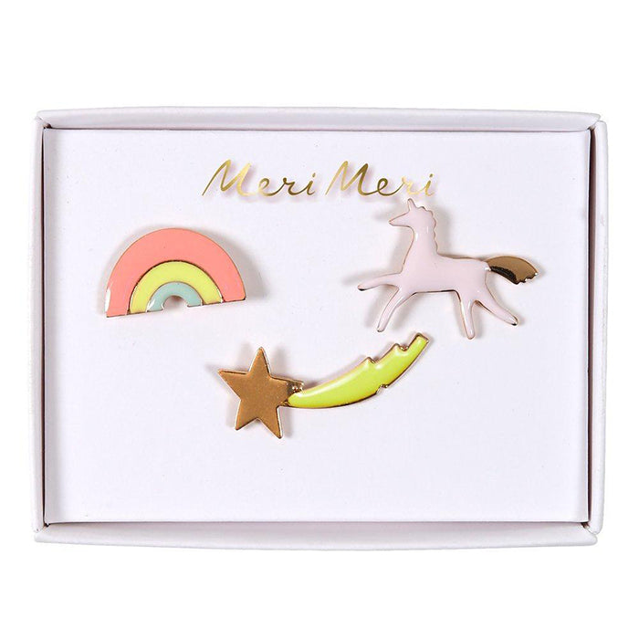 A box set of enamel pins of a unicorn, rainbow, and shooting star.