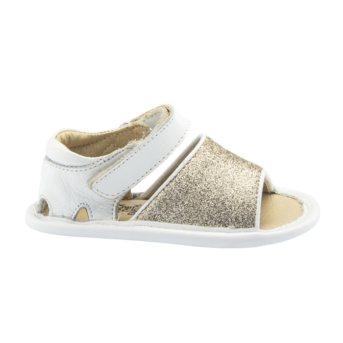White sandals with velcro closure around the ankle and a gold glitter strap across the foot from the side.