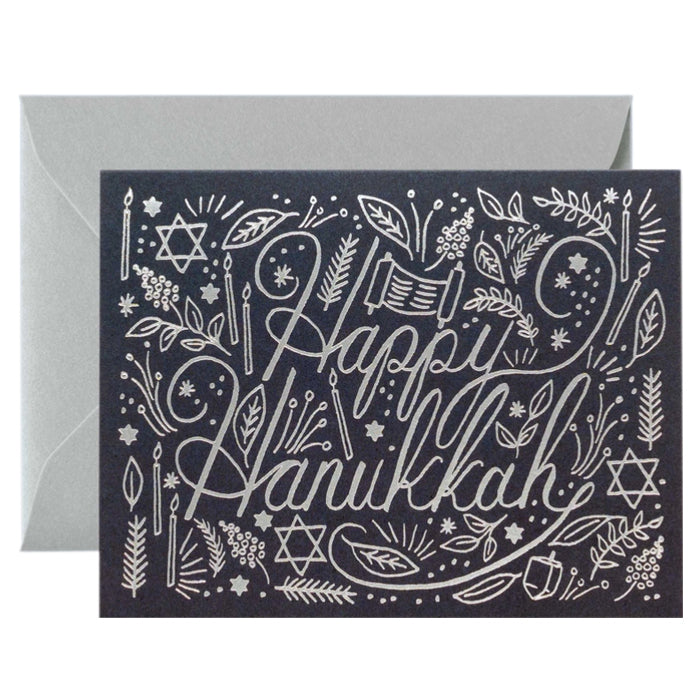 A navy Hanukkah card with a silver print over a silver envelope.