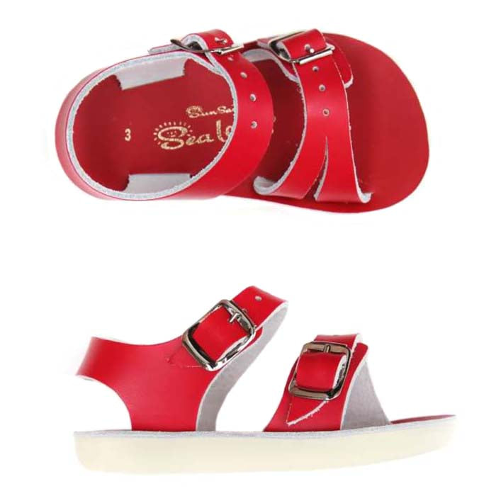 Red leather sandals with a buckled strap around the ankle and across the foot in two angles.